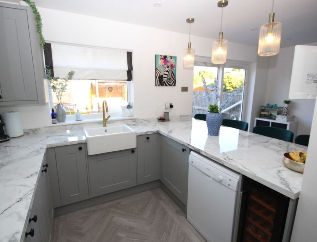 Grey shaker kitchen with marble-effect worktops and herringbone floor
